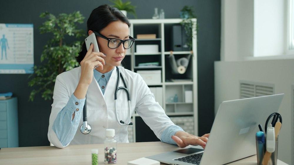 Clinical care coordinator taking patient appointment request and reviewing intake forms