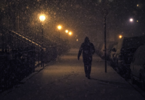 A person walking on a street in the snow