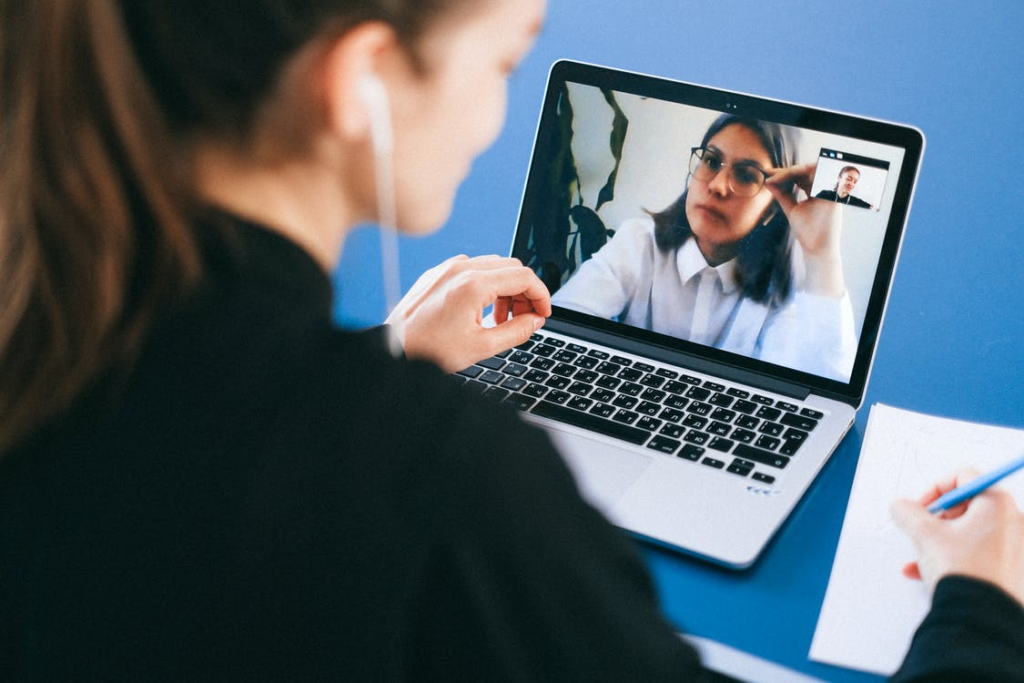 A doctor is making notes during her telepsychiatry appointment with a patient